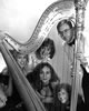 The five performers of Jeux looking through a harp in black & white