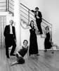 Black & white image of the Galliard Ensemble posing around a staircase