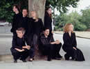 The Bennelong Ensemble sitting in front of a tree trunk