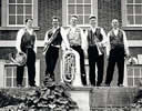 The artists standing in front of a period property with their instruments - black & white photo