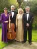 The four performers standing in a garden