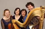 The artists standing behind a harp