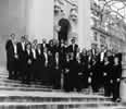 The Chameleon Arts Orchestra shown in black & white standing on stone steps