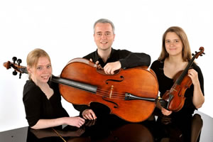 The Backman Trio standing with their instruments