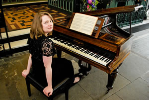 Julie Aherne seated at a piano