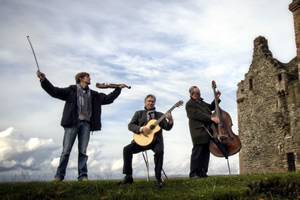 The Kliphuis Trio with their string instruments in scen outside with castle at side