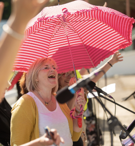 Clare Oliver standing under a bright red umbrella