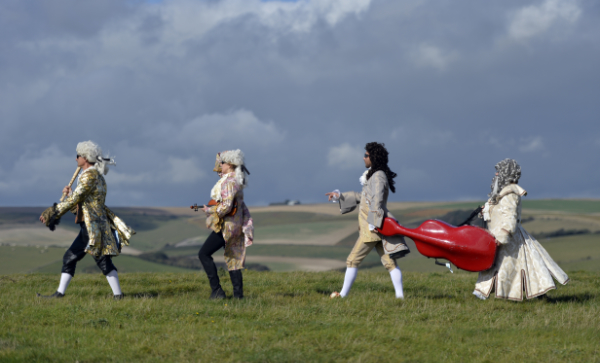 Red Priest walking across open ground in costume